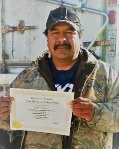 A photo of a person holding up his certificate of Completion