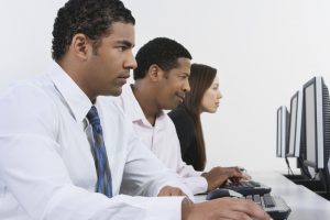 A photo of young multi-ethnic people looking at computer screens